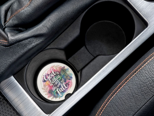 Car cup holder with a decorative coaster inside. The coaster features a colorful floral design and inspirational text, adding a cheerful touch.