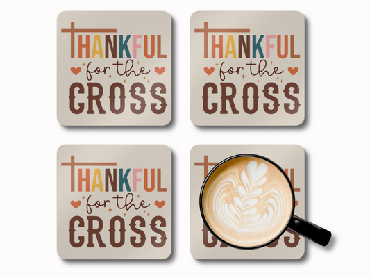 Set of four “Thankful for the Cross” scripture coasters with latte art coffee cup.