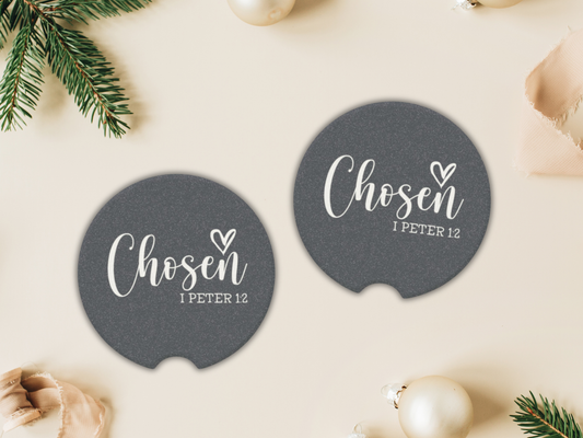 Two round navy coasters with 'Chosen 1 Peter 1:2' text on a light background with Christmas decorations.