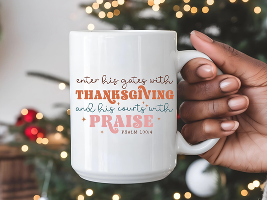 White mug with text held by a hand in front of a Christmas tree with lights.