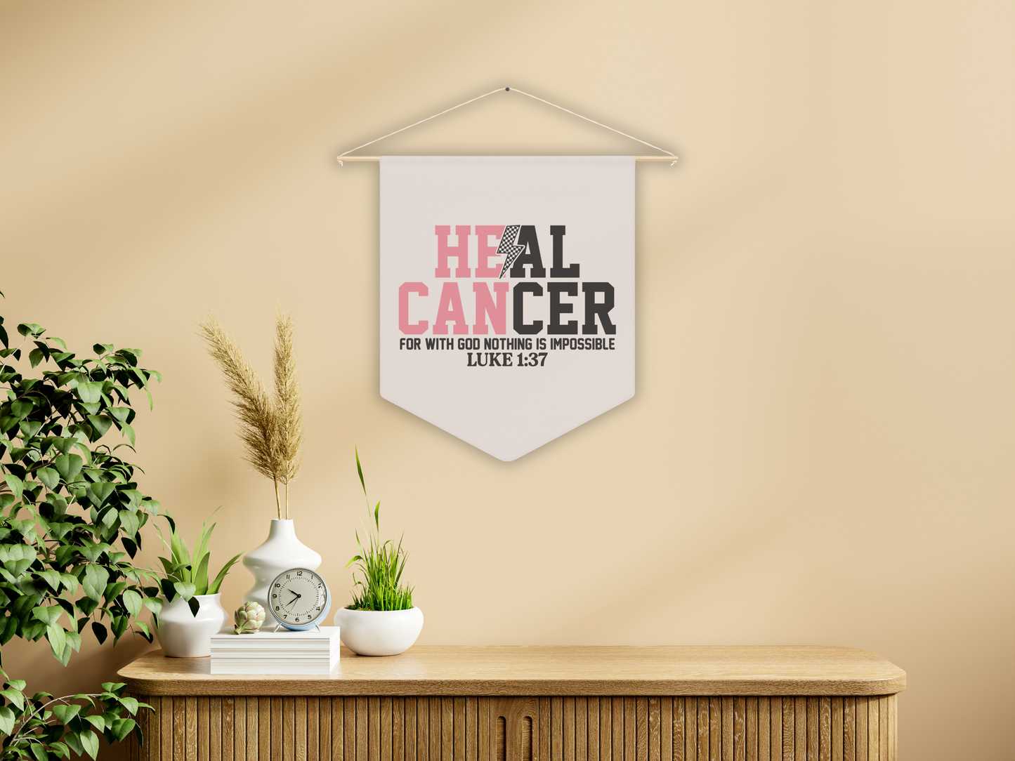 Decorative wall pennent with motivational quote on a wall above a wooden cabinet.