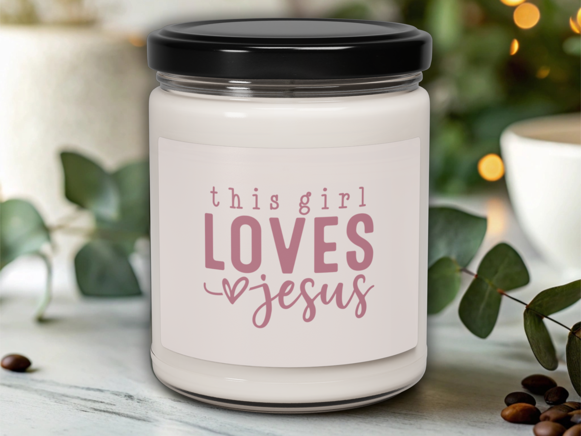 Candle jar with 'this girl loves Jesus' text on a blurred background