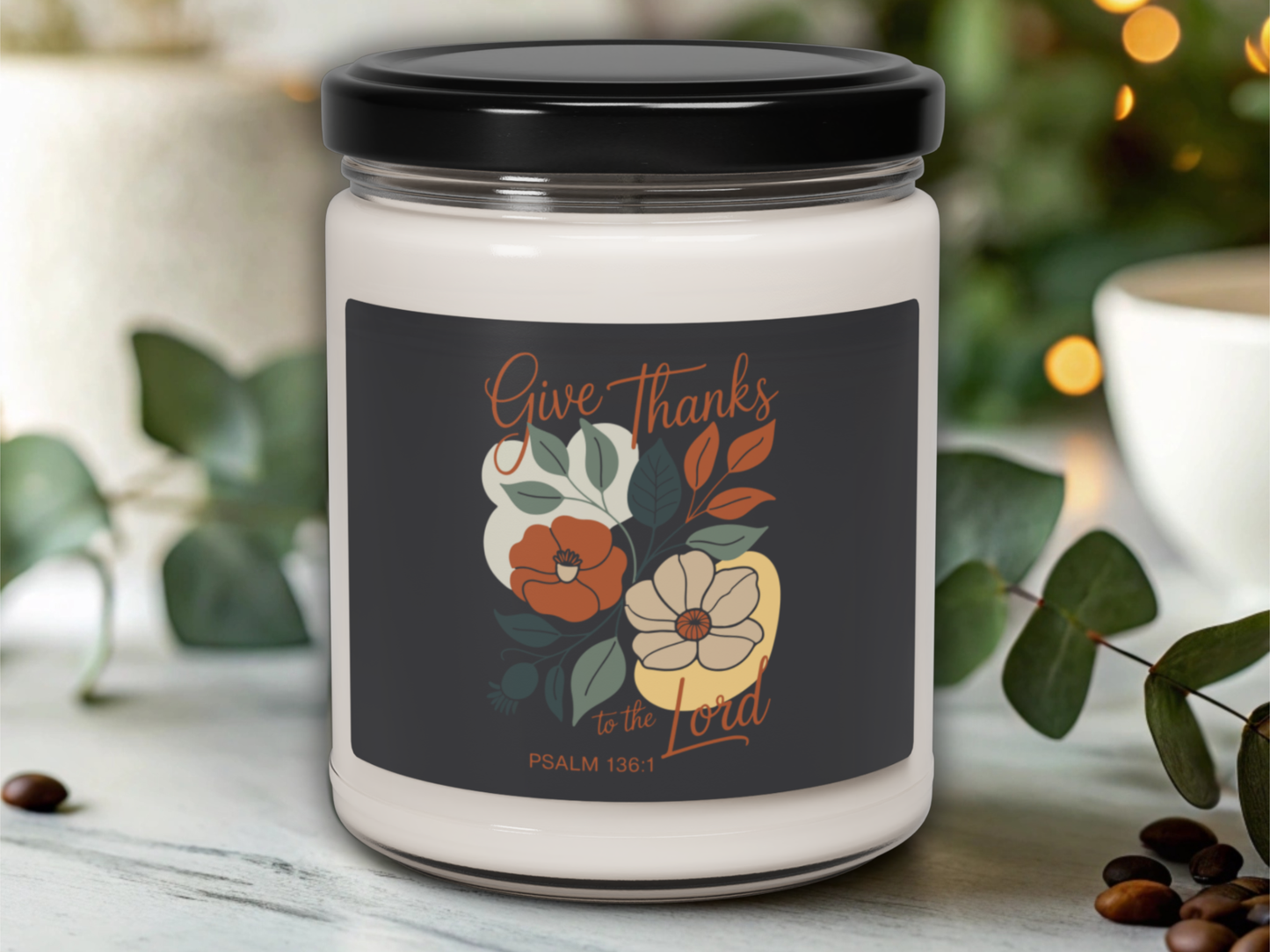 Candle jar with a decorative label featuring floral designs and text on a blurred background.