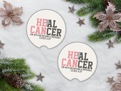 Two 'HEAL CANCER' car coasters with Christmas decorations on a snowy background