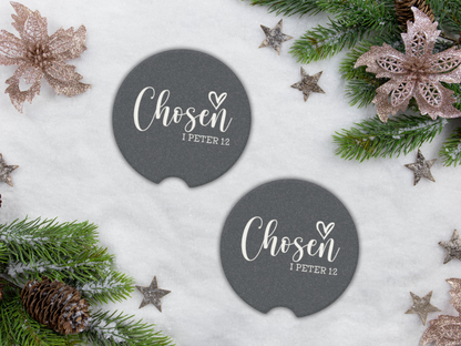 Two navy car coasters with 'Chosen I Peter 1:2' text on a snowy background with Christmas decorations.