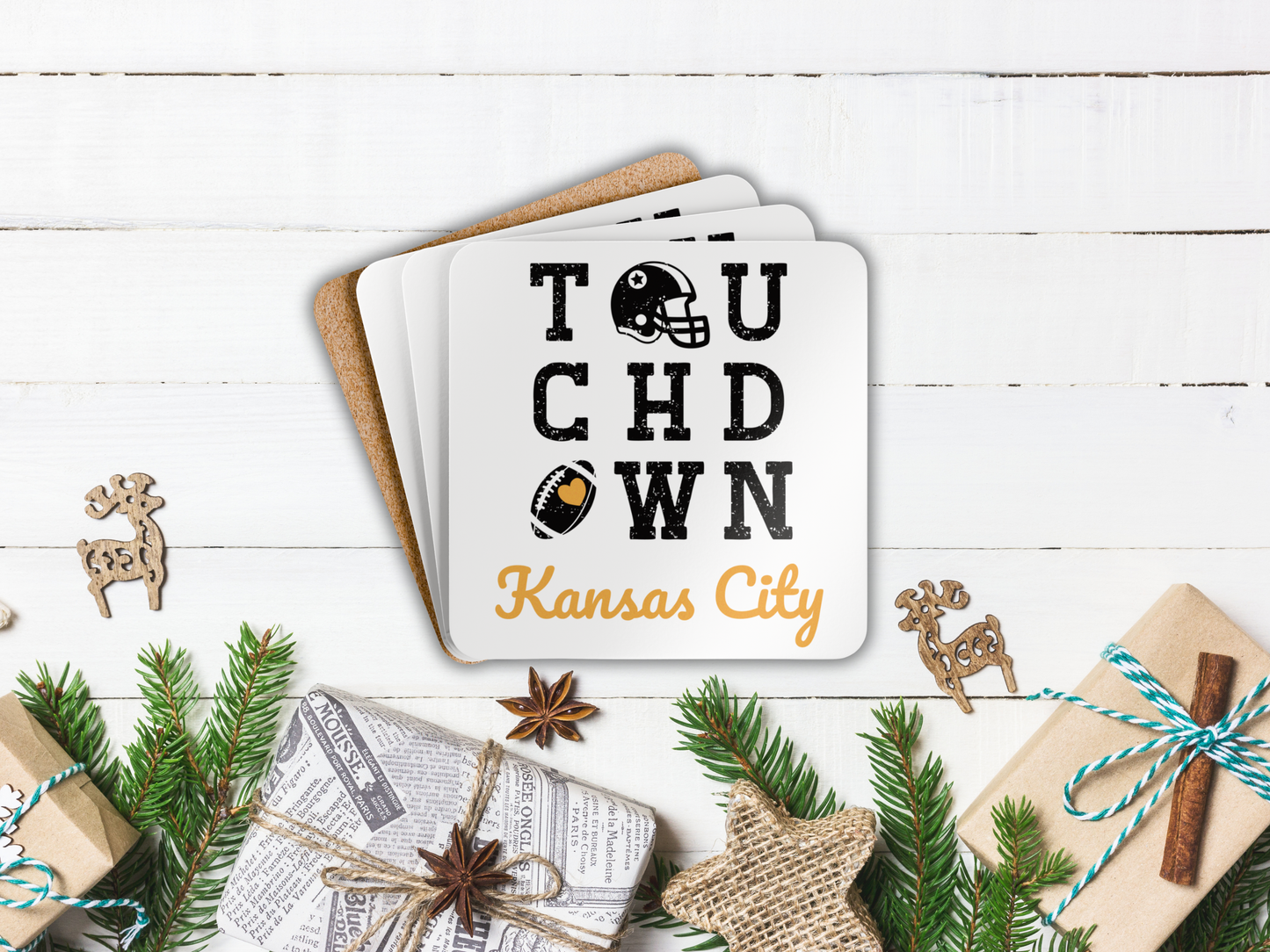 Stack of coasters with 'Touchdown Kansas City' design on a wooden surface with Christmas decorations.