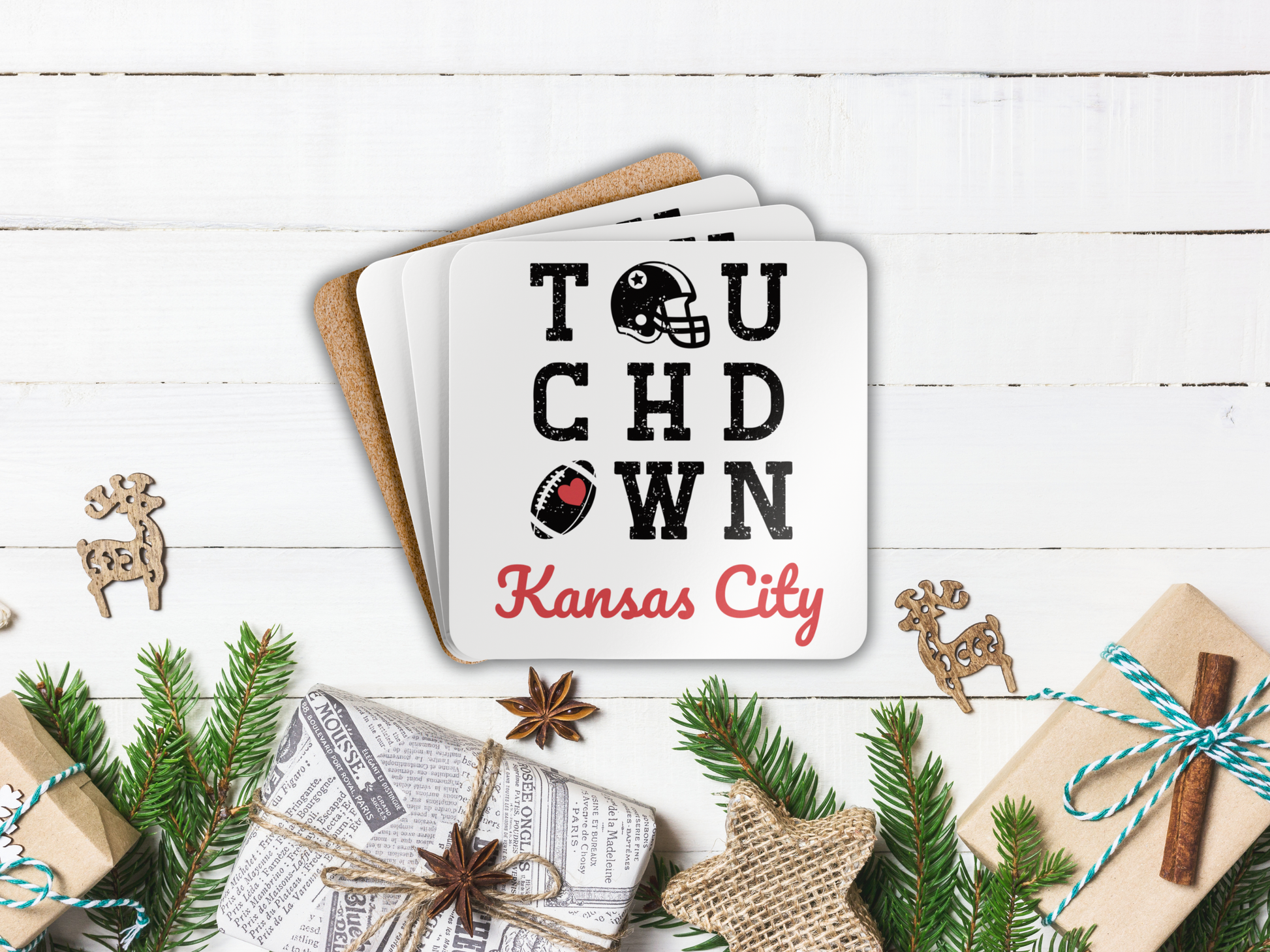 Stack of coasters with 'Touchdown Kansas City' design on a festive background with Christmas decorations.