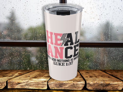 Pink tumbler with motivational quote on a wooden surface with a blurred background