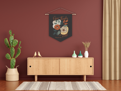 Decorative wall hanging with floral design above a wooden cabinet in a room with a plant and vases.