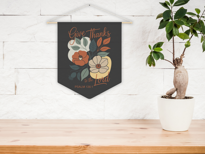 Decorative wall hanging with floral design and text on a wooden surface with a plant.