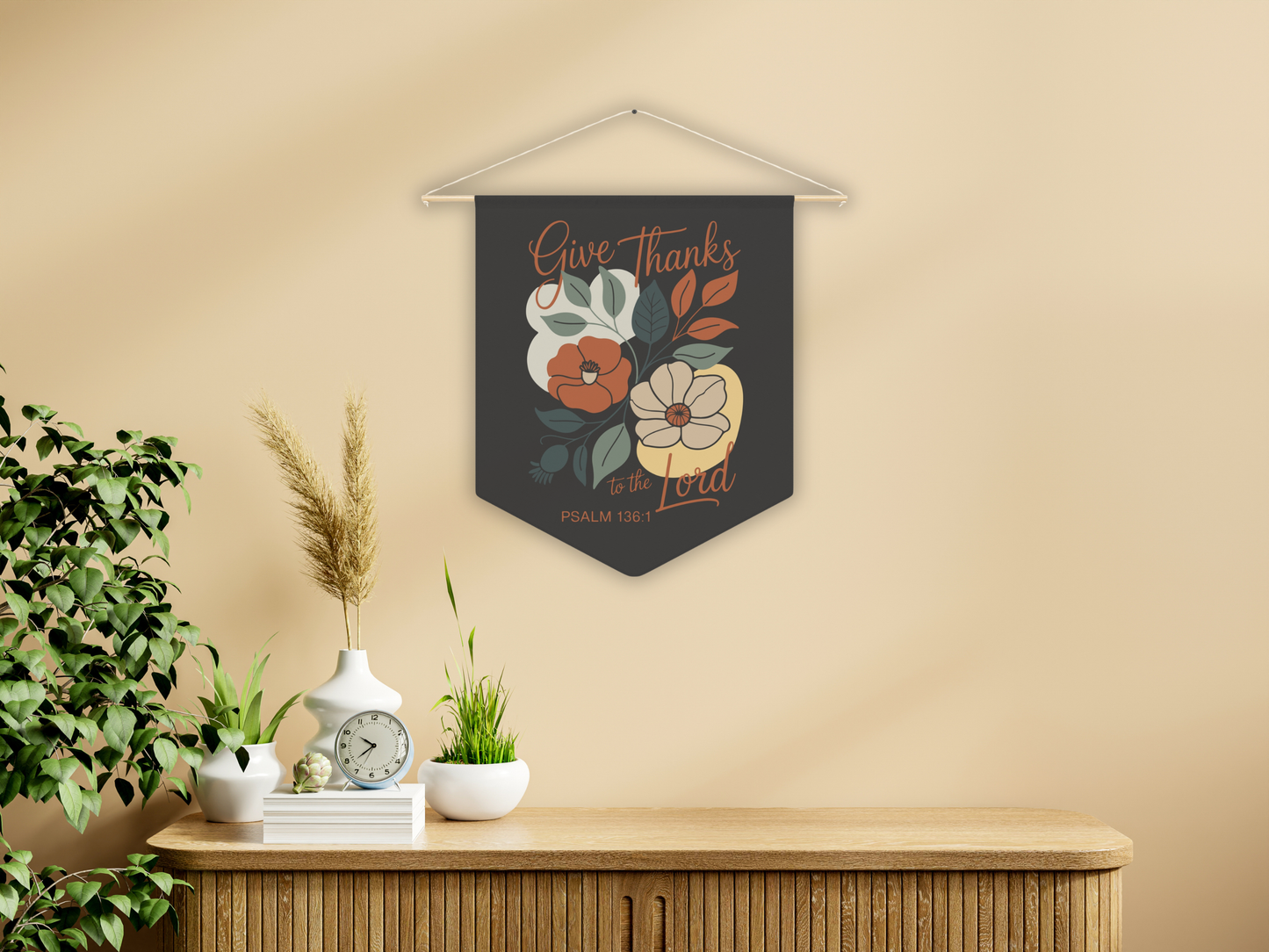 Decorative wall art with floral design and text on a beige wall above a wooden cabinet.