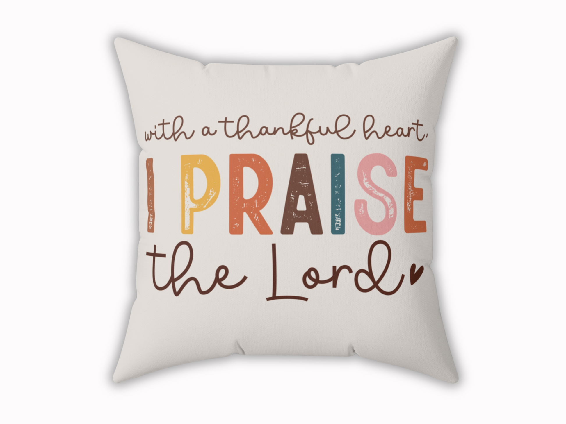 A cream pillow featuring the phrase "With a thankful heart, I praise the Lord" in playful, colorful fonts. The design conveys gratitude and joy.