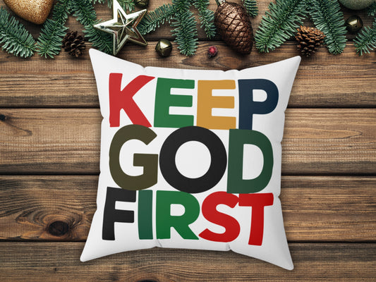 Decorative pillow with 'KEEP GOD FIRST' text on a wooden surface with Christmas decorations.