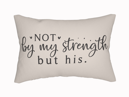 A beige pillow with the phrase "Not by my strength but his" in elegant black script and print, conveying a tone of faith and inspiration.