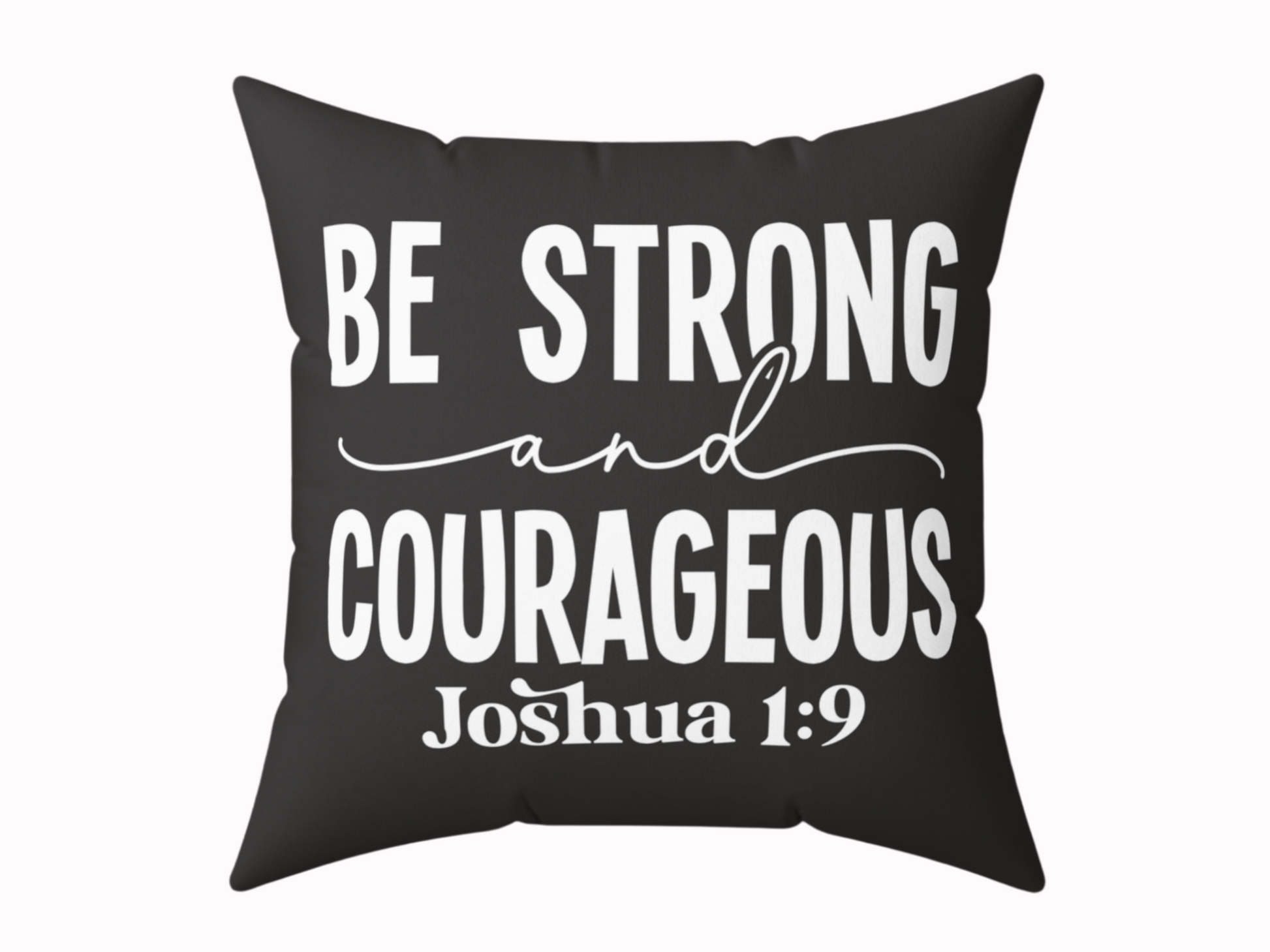 Black cushion with bold white text: "Be Strong and Courageous" in a mix of script and block fonts. Below, "Joshua 1:9" is printed in smaller text.