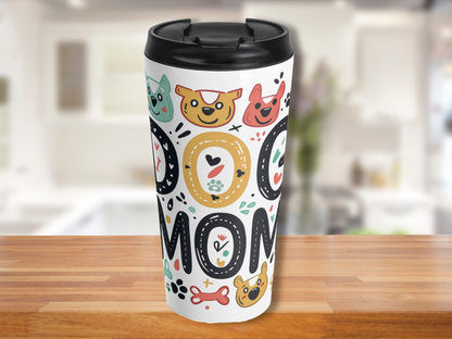 Travel mug on a wooden table, featuring colorful dog graphics and the words "DOG MOM" in bold letters. The background is a bright kitchen.