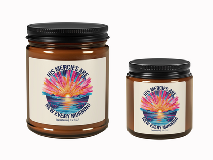 Two brown candles with black lids, featuring a colorful sunrise design and the text "His Mercies Are New Every Morning, Lamentations 3:22-23."