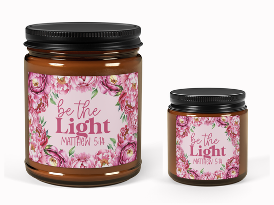 Two brown jars with black lids featuring floral labels. The labels display pink peonies and the text "be the Light, Matthew 5:14" in elegant fonts.
