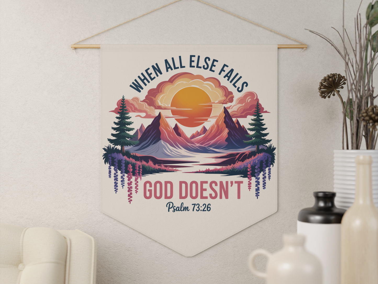 A decorative wall art hanging features a vibrant sunset over mountains and trees, with the text, “When all else fails, God doesn’t. Psalm 73:26." Peaceful ambiance.