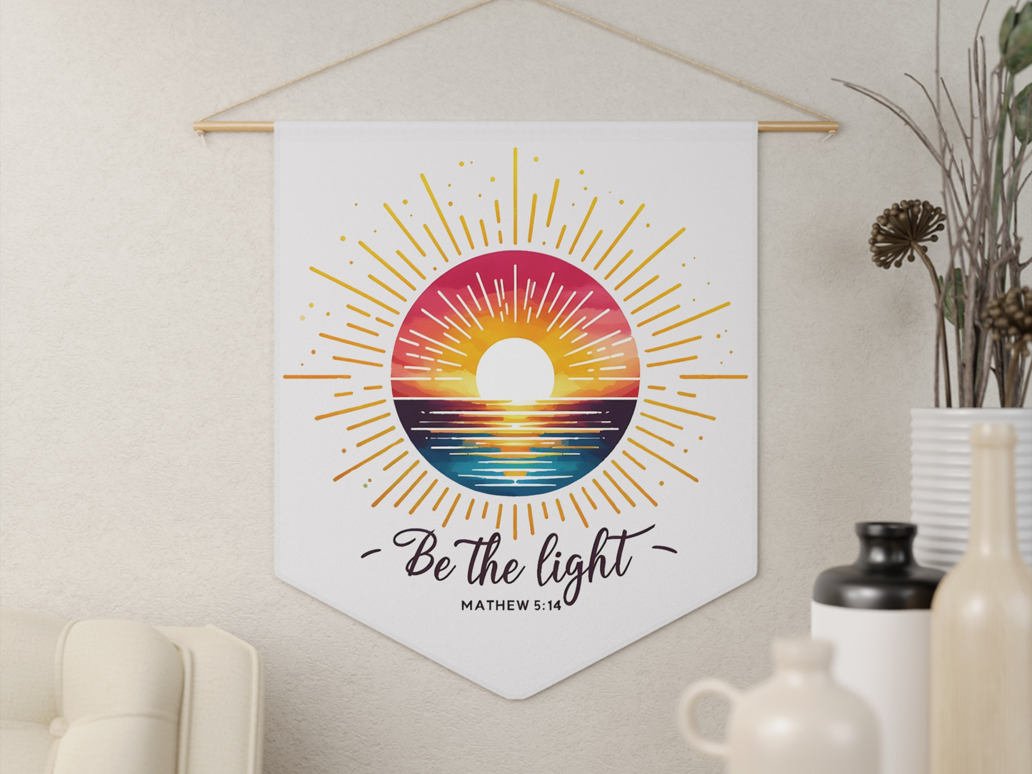 A wall hanging features a colorful sunrise over the ocean with radiant beams. Below, the words "Be the light" and "Matthew 5:14" offer inspiration.