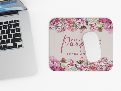 A sleek laptop beside a floral mousepad with a white mouse. The mousepad features vibrant pink and white peonies and a motivational quote.