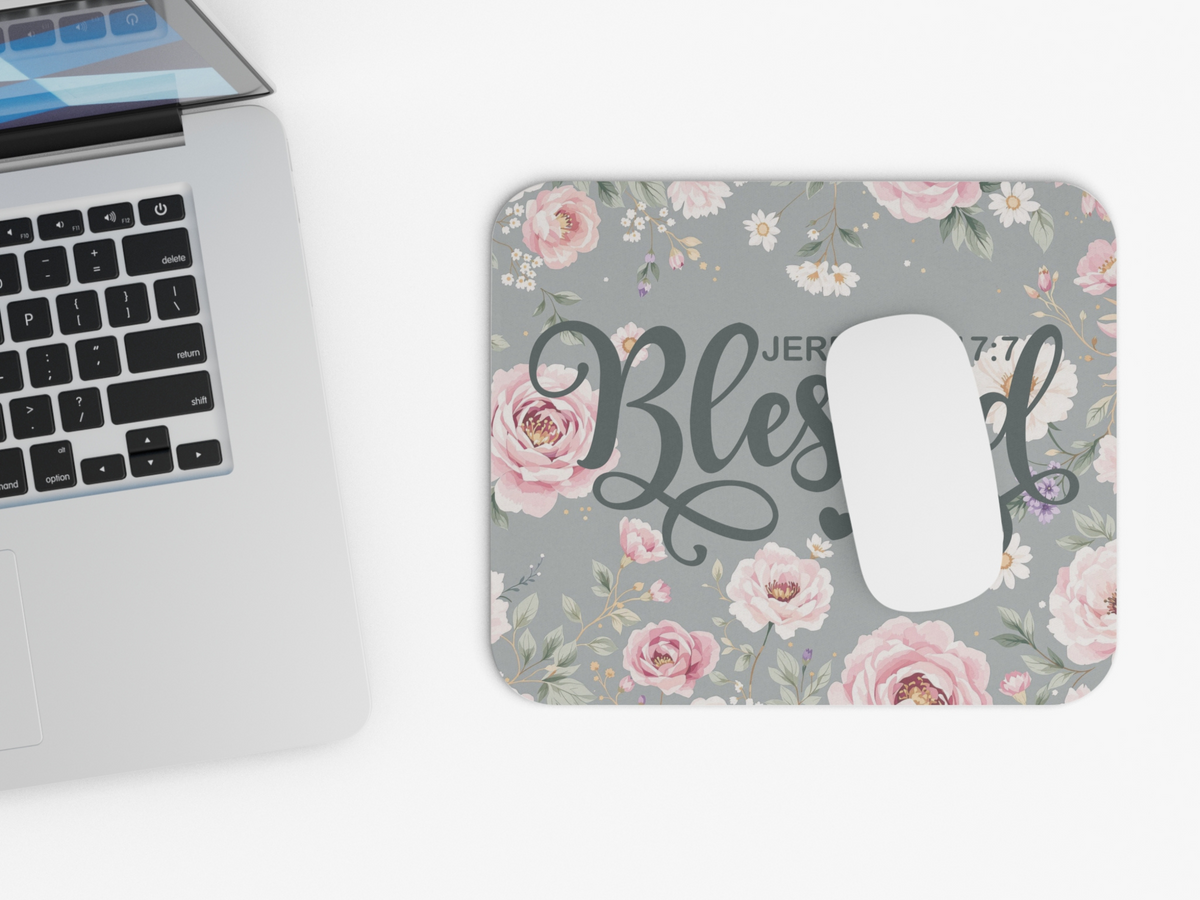 Mouse pad with pink floral design and "Blessed" text alongside a laptop. The mood is peaceful and uplifting.