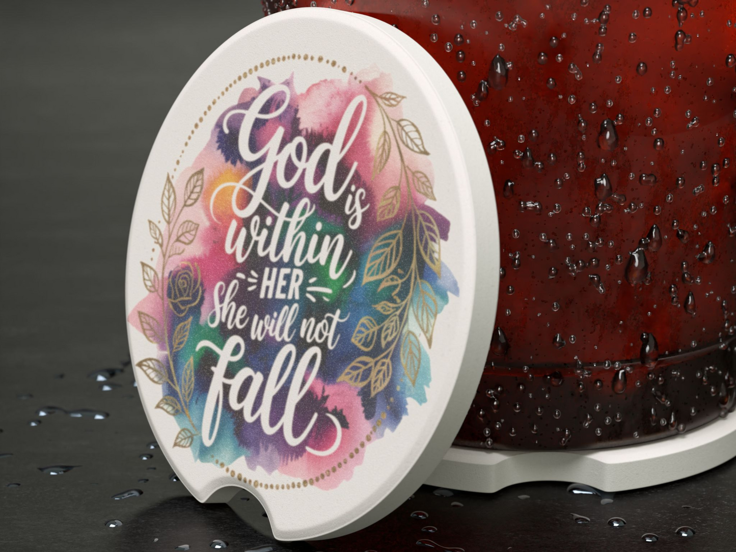 White coaster with colorful watercolor design and floral accents, featuring the inspirational text "God is within her, she will not fall." Adjacent to a wet surface.