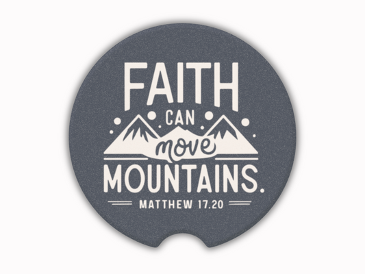 A car cup coaster with white text and mountain illustrations reads, "Faith can move mountains, Matthew 17:20," conveying inspiration and hope.
