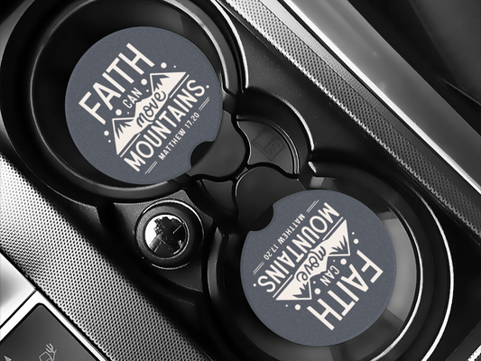 Car cup holder with round coasters displaying "Faith can move mountains, Matthew 17:20" in white text on a dark background, emphasizing hope.