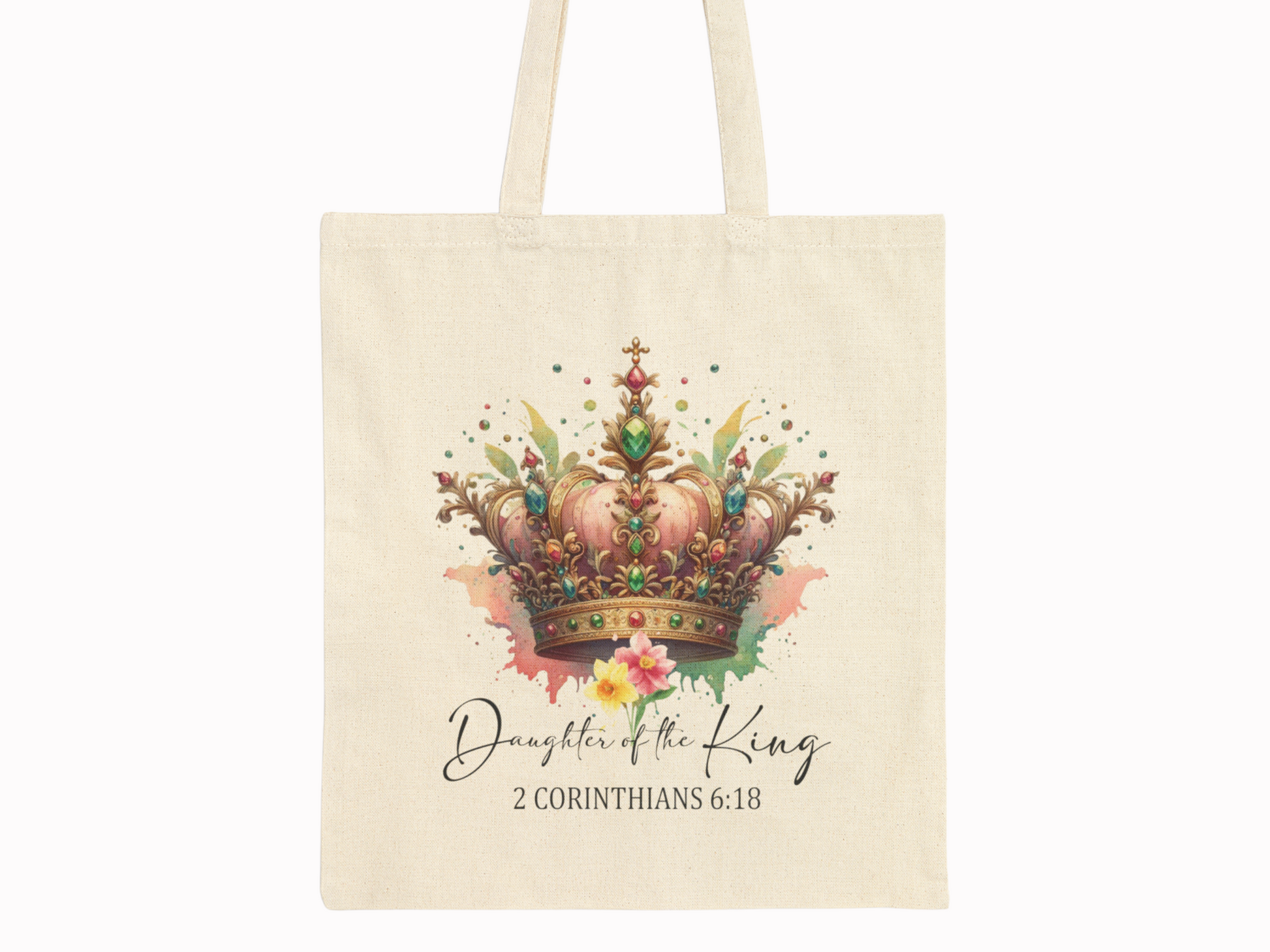 A beige tote bag features a vibrant, ornate crown with jewels and floral elements. Below, it reads "Daughter of the King, 2 Corinthians 6:18" in elegant script.