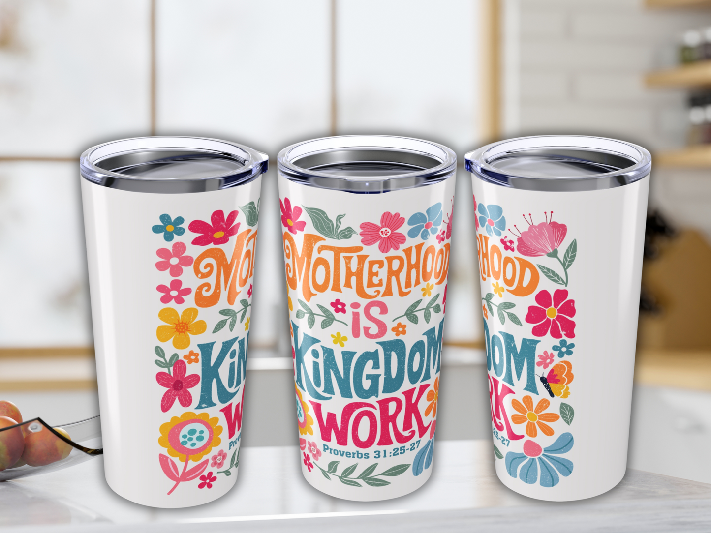 Three insulated cups with floral designs and motivational text: "Motherhood is Kingdom Work." Bright colors create a cheerful, uplifting tone.