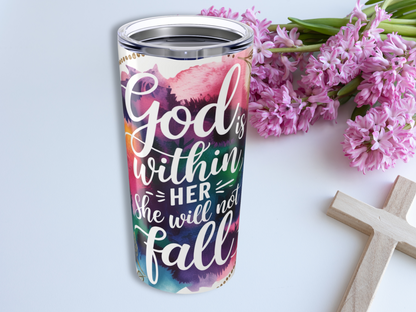 A colorful religious tumbler with the text "God is within her, she will not fall" is beside pink flowers and a wooden cross, conveying faith and positivity.