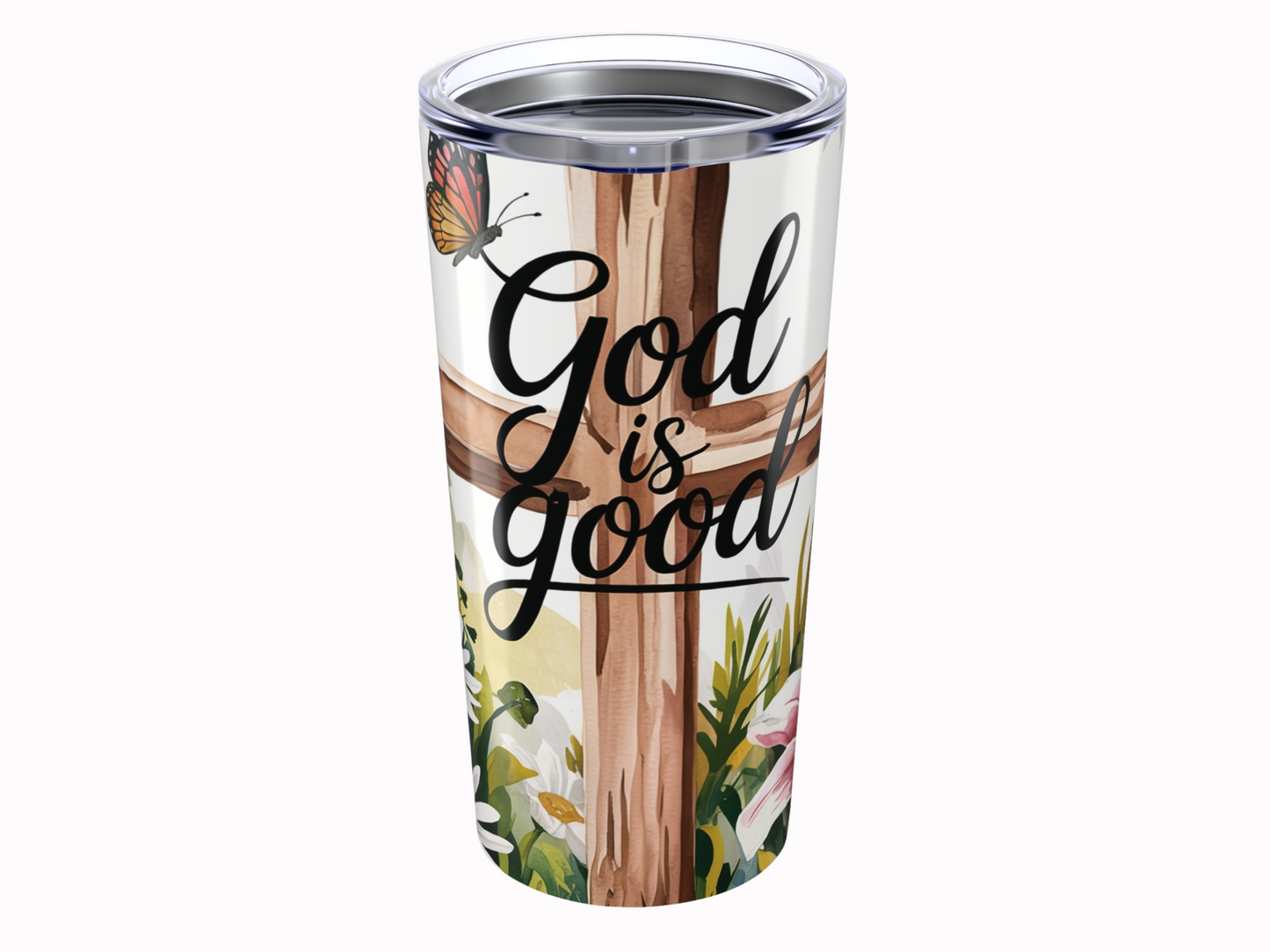 Tumbler with "God is good" text over a wooden cross. A butterfly and flowers add a serene, uplifting tone, blending nature and faith.