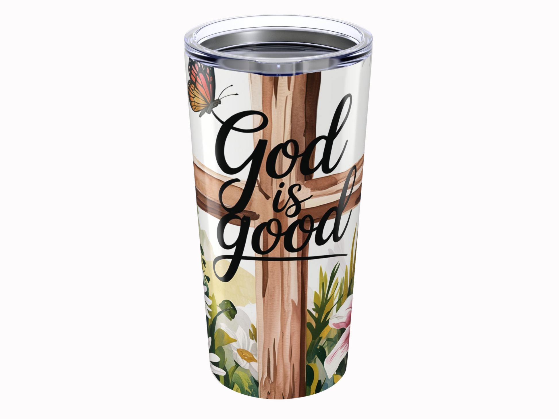 Tumbler with "God is good" text over a wooden cross. A butterfly and flowers add a serene, uplifting tone, blending nature and faith.