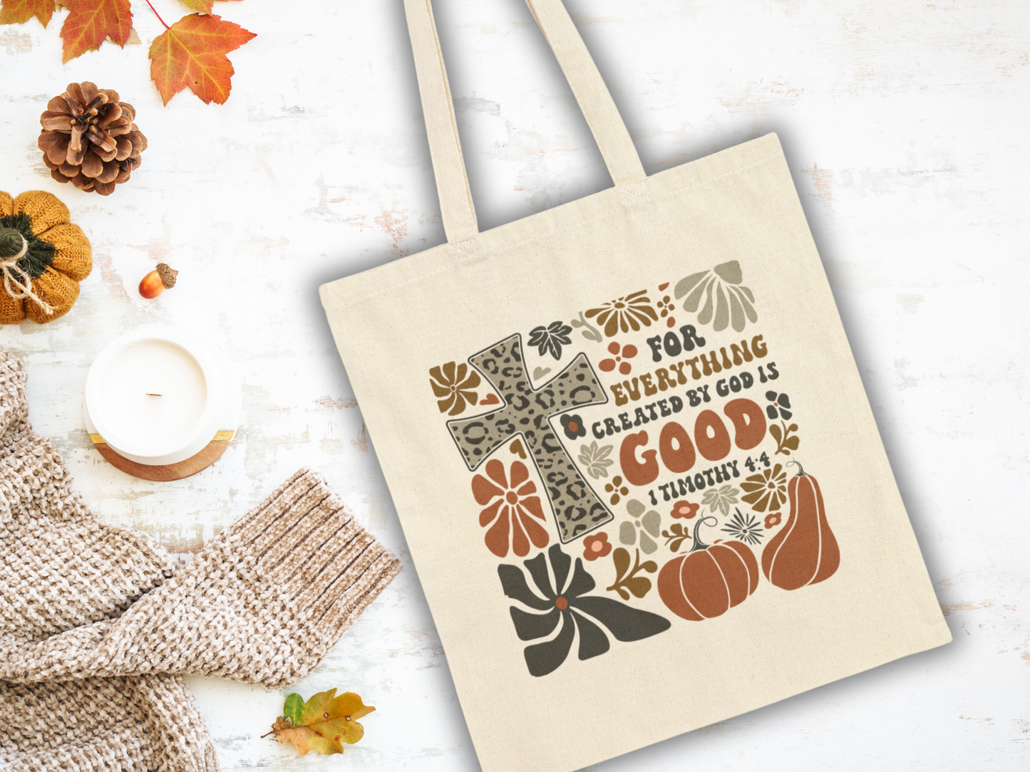 Tote bag with cross and 'For everything God is good' text on a fall-themed background