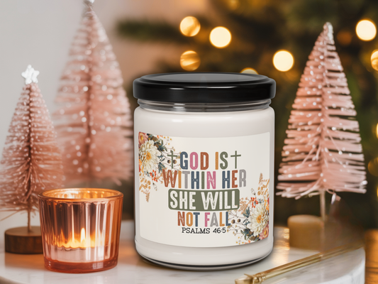 Candle jar with motivational quote in a festive setting with Christmas trees and lights.
