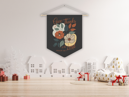 Decorative wall pennant with floral design and text on a white wall with Christmas decorations below.