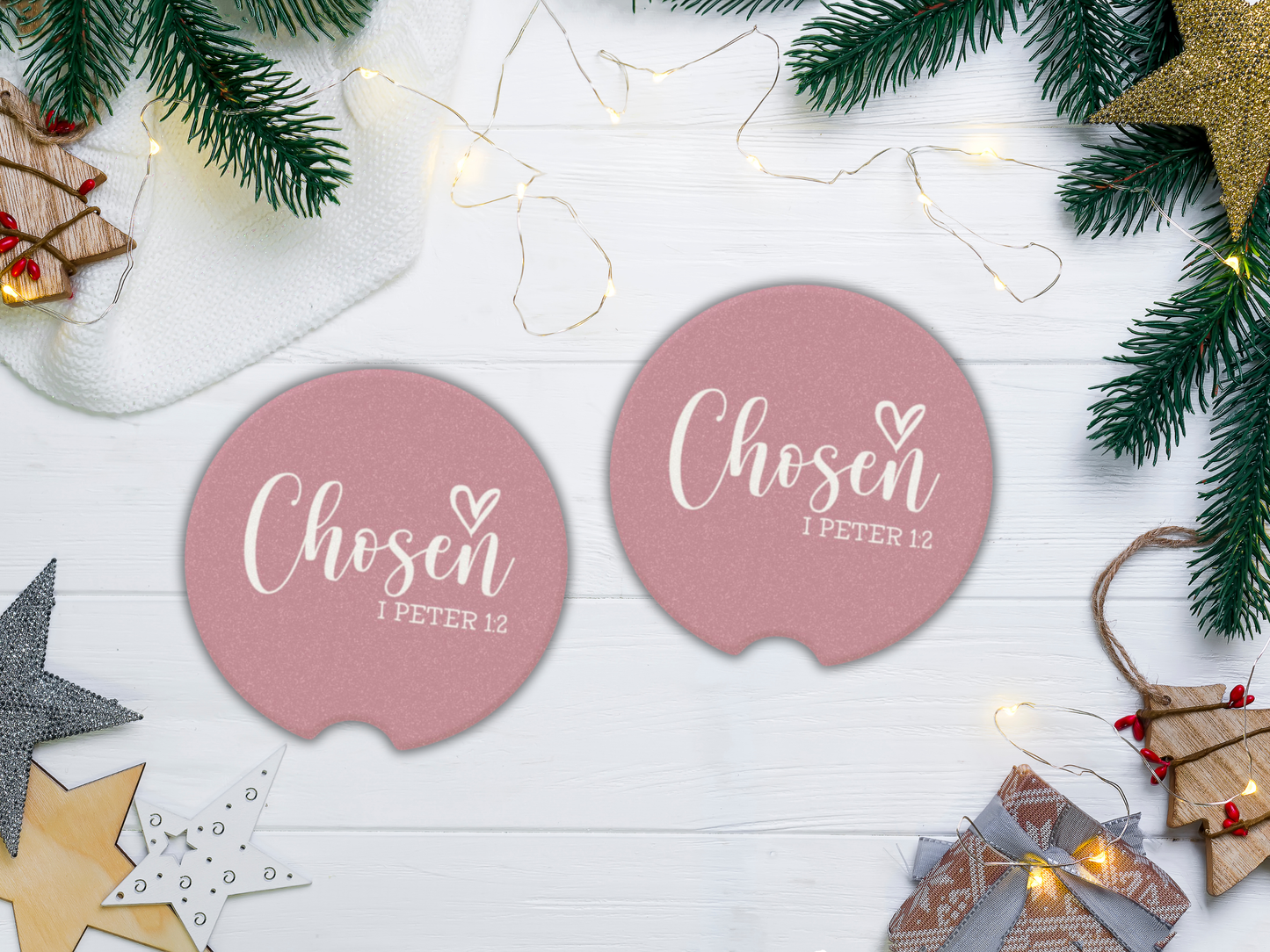 Two pink coasters with 'Chosen 1 Peter 1:2' text on a festive background with Christmas decorations.