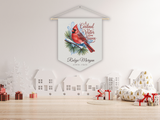 Decorative wall hanging with a cardinal design on a white wall with Christmas decorations.