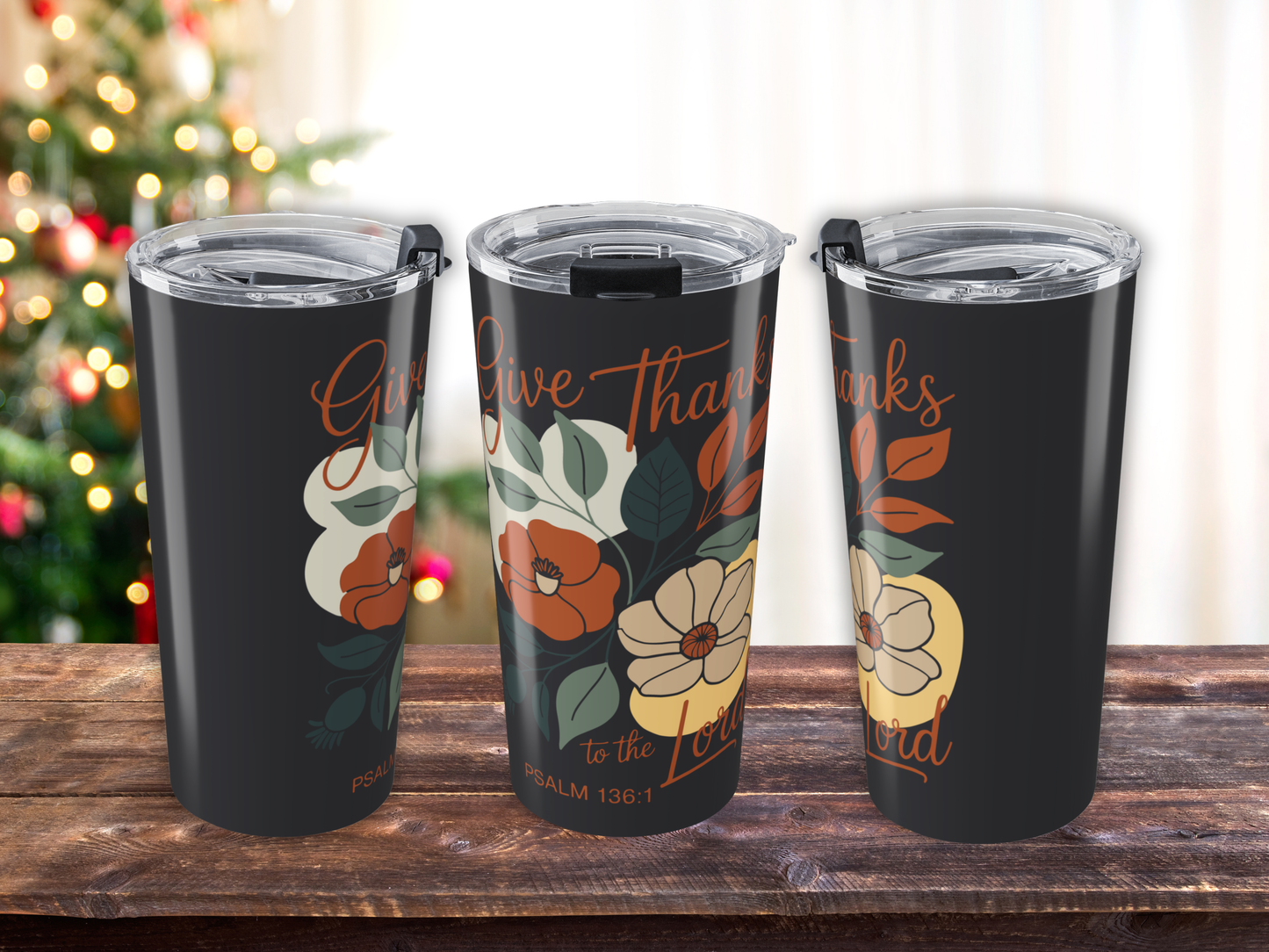 Three tumblers with floral designs and 'Give Thanks' text on a wooden surface.