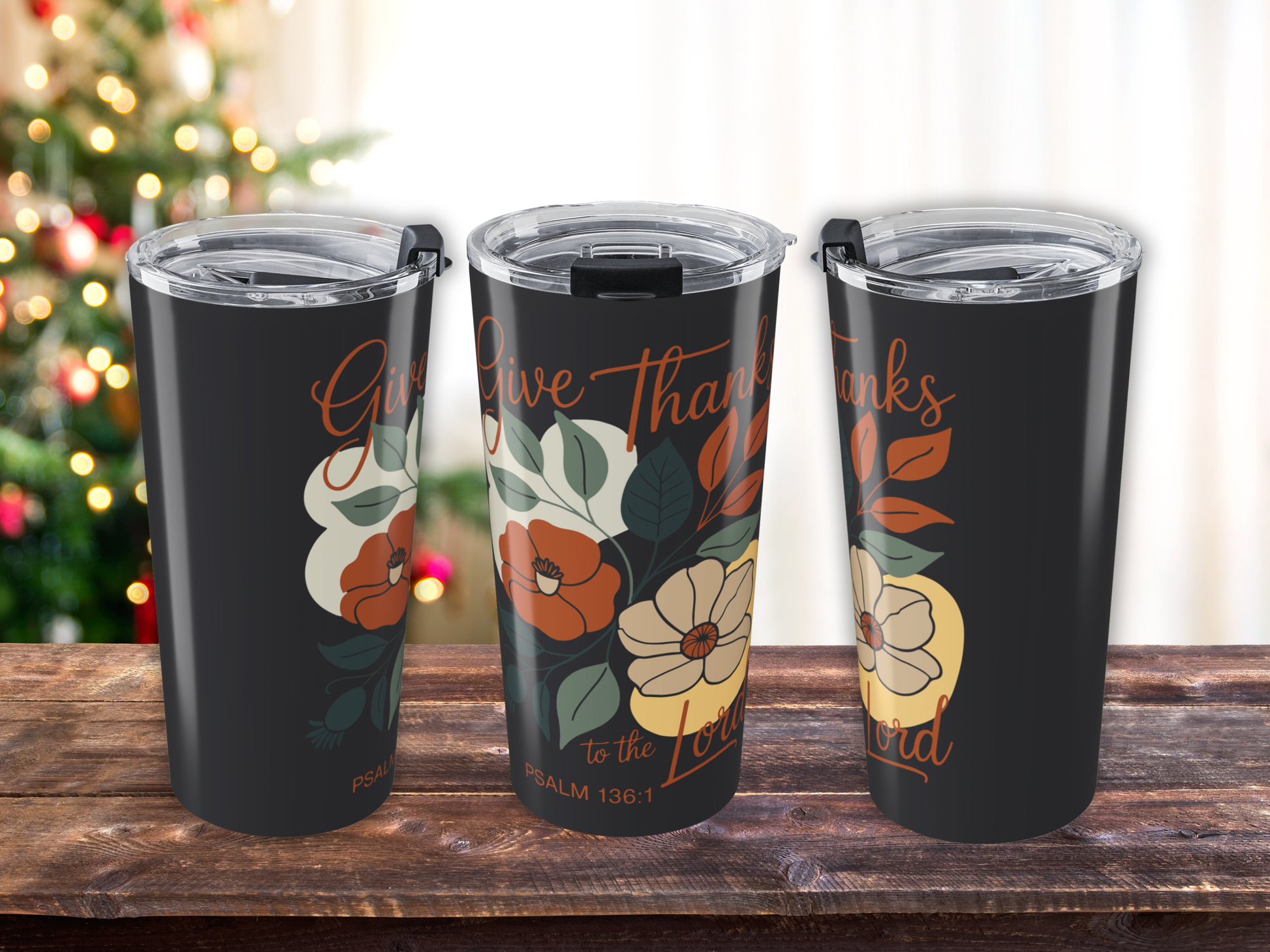 Three tumblers with floral designs and 'Give Thanks' text on a wooden surface.