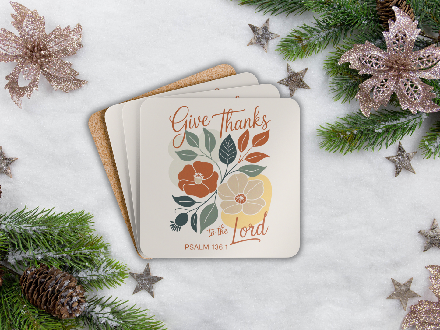 Coaster set with floral design and text 'Give Thanks to the Lord' on a snowy background with Christmas decorations.