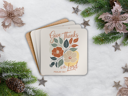 Coaster set with floral design and text 'Give Thanks to the Lord' on a snowy background with Christmas decorations.