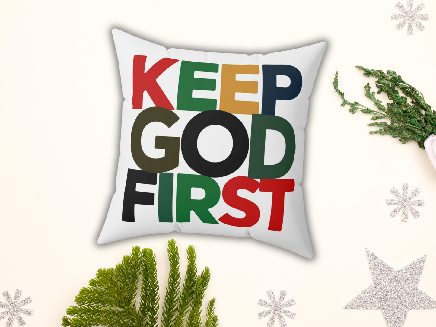 Decorative pillow with 'KEEP GOD FIRST' text on a white background with Christmas decorations.