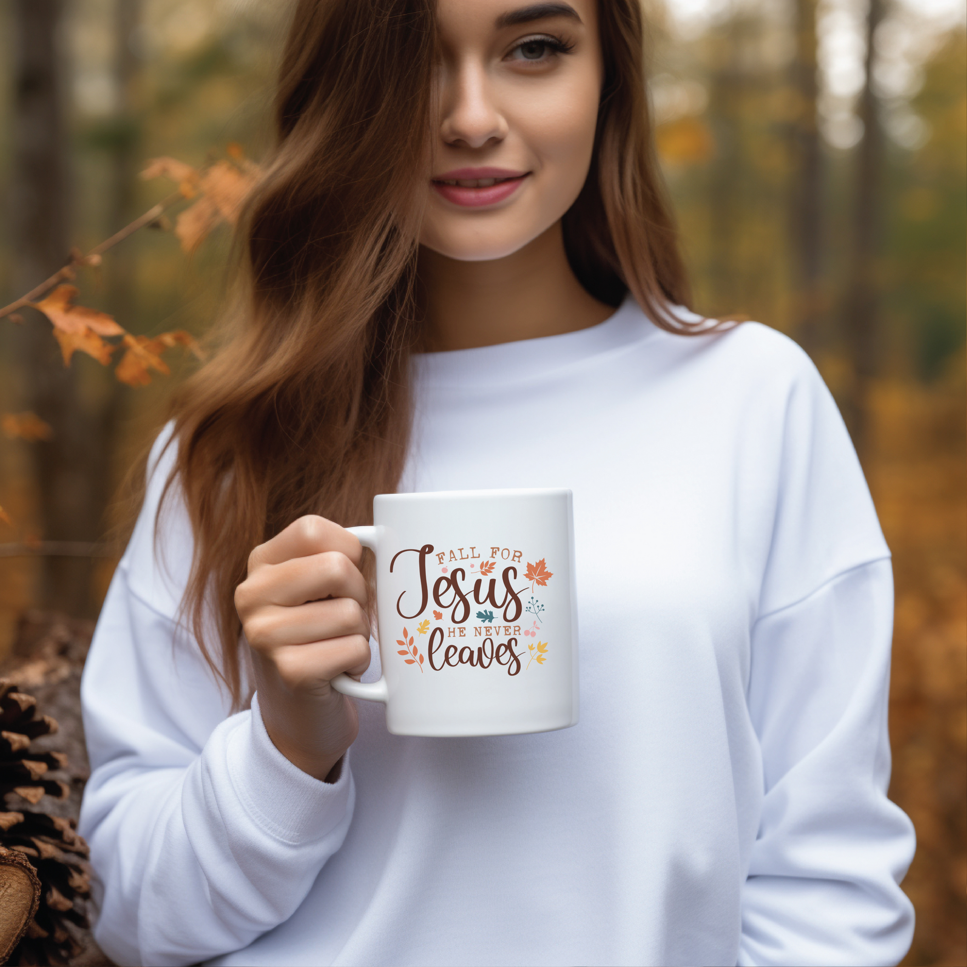 Woman holding a mug with 'Fall for Jesus over leaves' text in an autumn setting