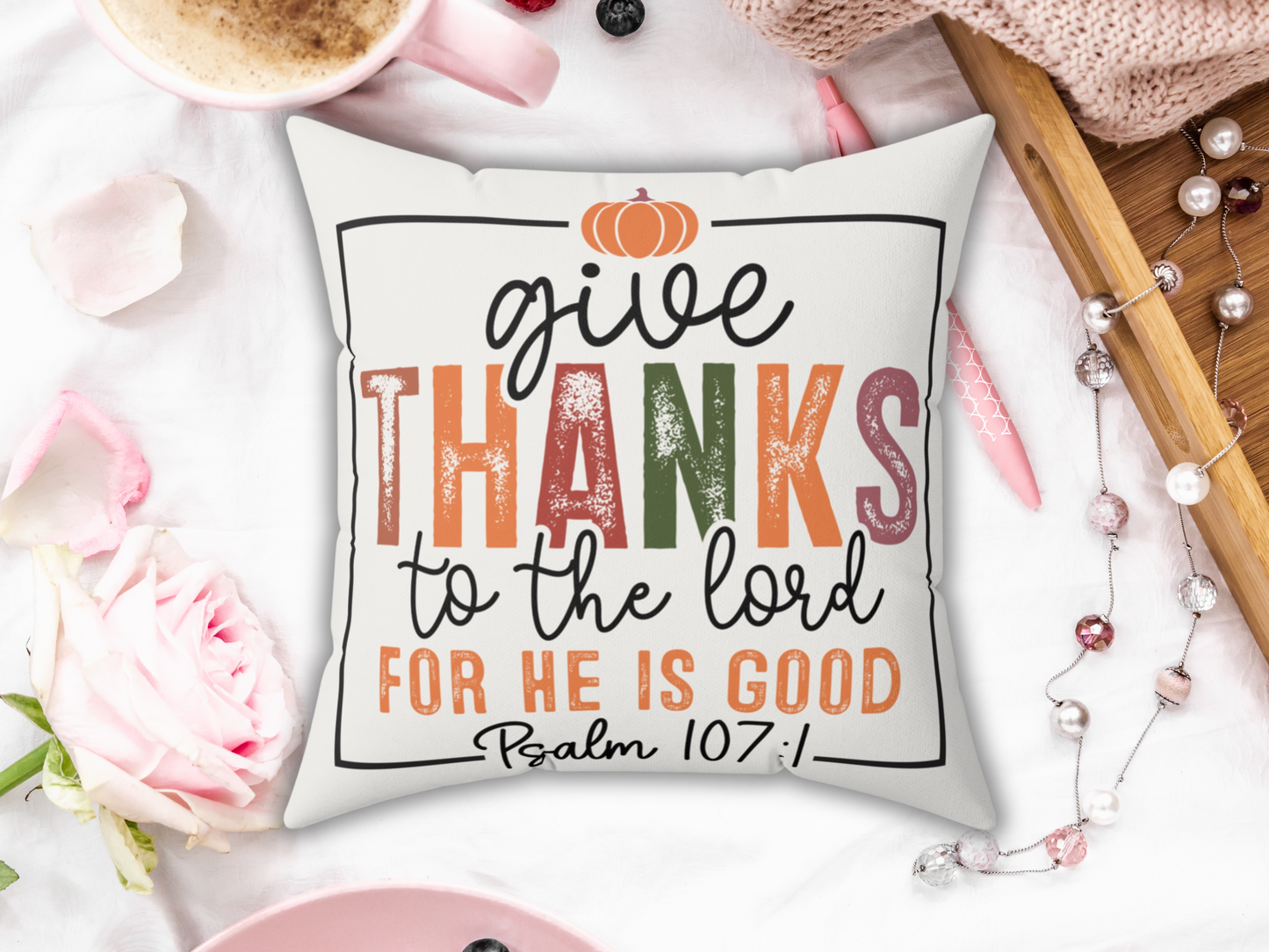 “Give Thanks to the Lord” pillow displayed with pink coffee cup, roses, pearls, and cozy textures.