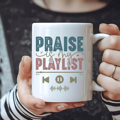 Person holding a mug with 'Praise is my playlist' text design.