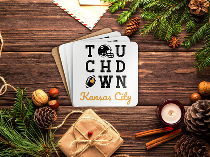 Coaster set with 'Touchdown Kansas City' text on a wooden surface with Christmas decorations.