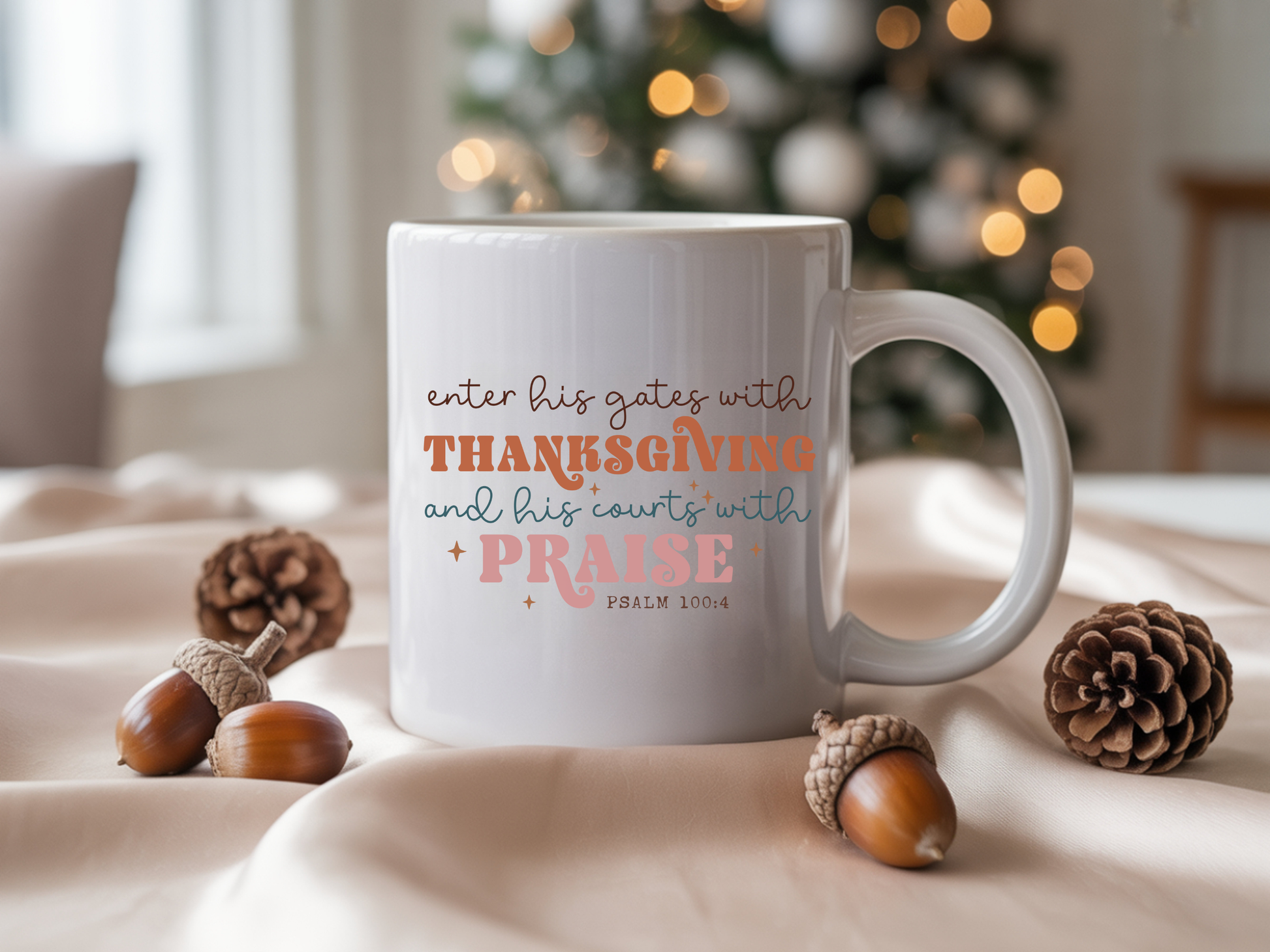 White mug with inspirational quote on a table with pinecones and acorns, Christmas tree in the background