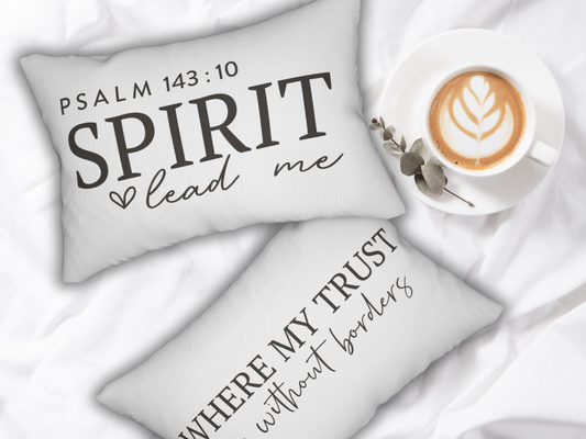 Decorative pillows with inspirational quotes and a cup of coffee on a soft surface.